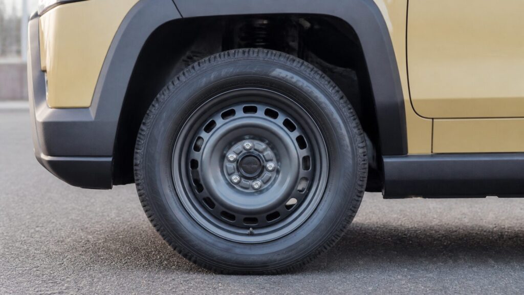 Close-up of a TAFT front wheel and tyre, the wheel arch and steel-look alloy wheel filling the frame, parked o