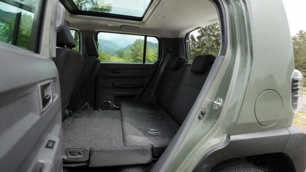 Interior of a TAFT seen through the open rear door, showing the rear seats and cargo area, natural daylight, n